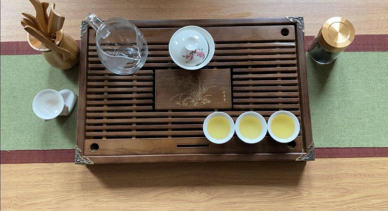 Traditional Chinese tea ceremony with a gaiwan, teacups, and tea tray